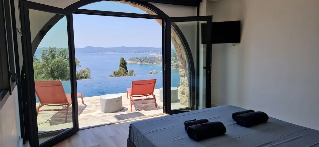Chambre en arc de la Villa GL., portes ouvertes sur la terrasse et la mer